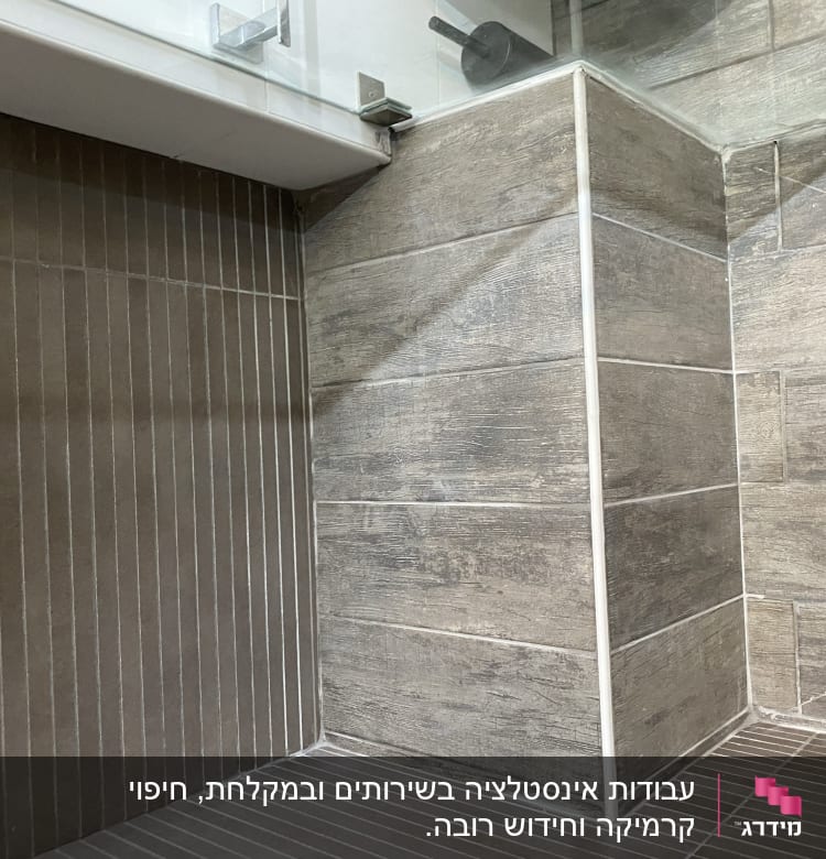 אריחי קרמיקה מותקנים בפינת חדר עם חיפוי זכוכית